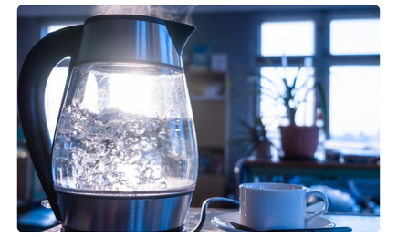 A boiled crystal-clear water beside a cup and saucer, symbolizing the benefits of a Renewell Water softener in reducing limescale buildup, improving taste, and protecting appliances.