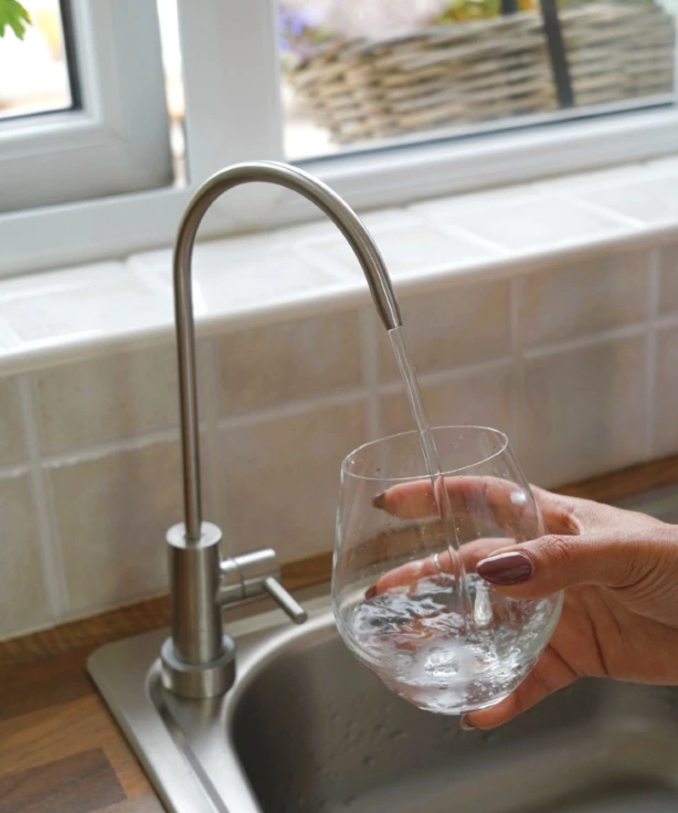 filling water glass with filtered water